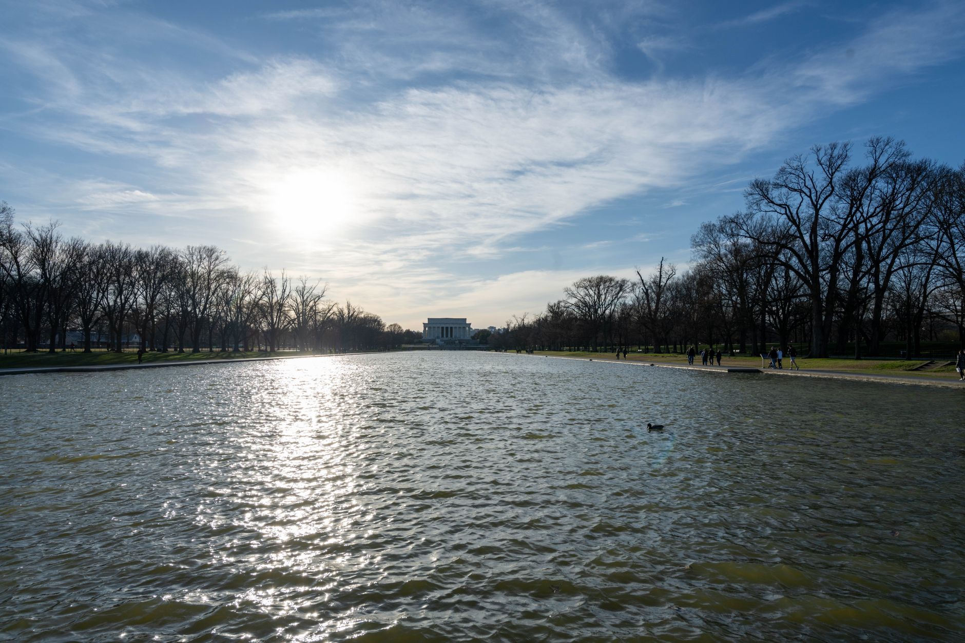 The Lincoln Memorial Reflecting Pool with serene water and clear sky in Washington DC.