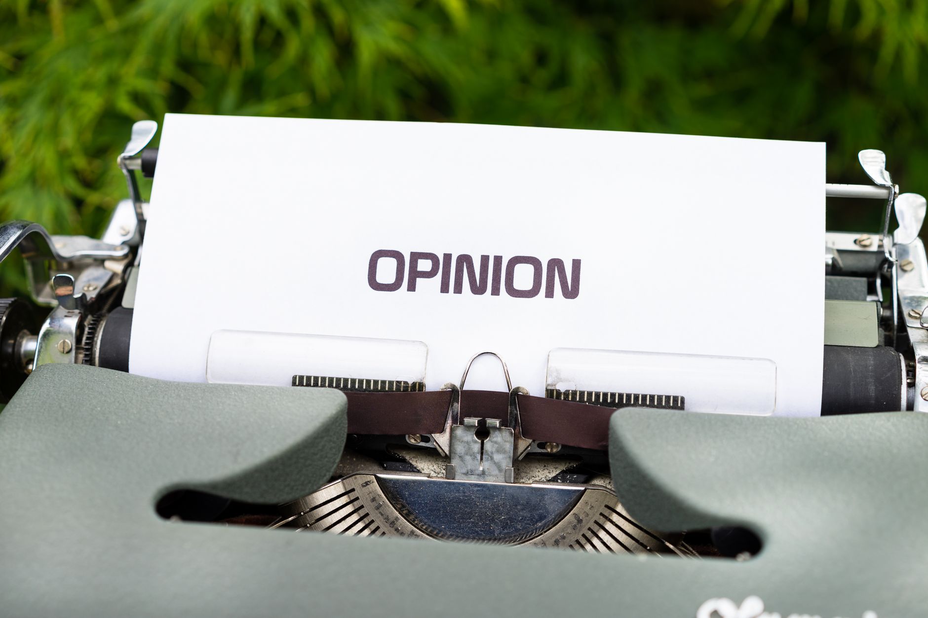 Close up of a typewriter with paper showing the word &amp;#39;Opinion&amp;#39; outdoors.